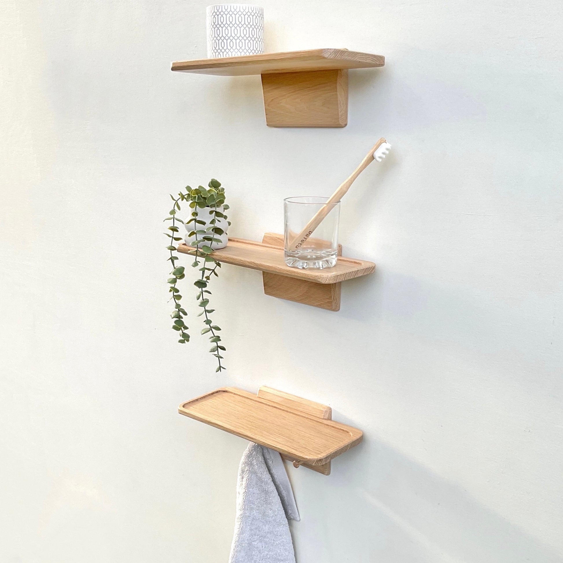 A group of oak bathroom shelves both with and without towel hanging hooks