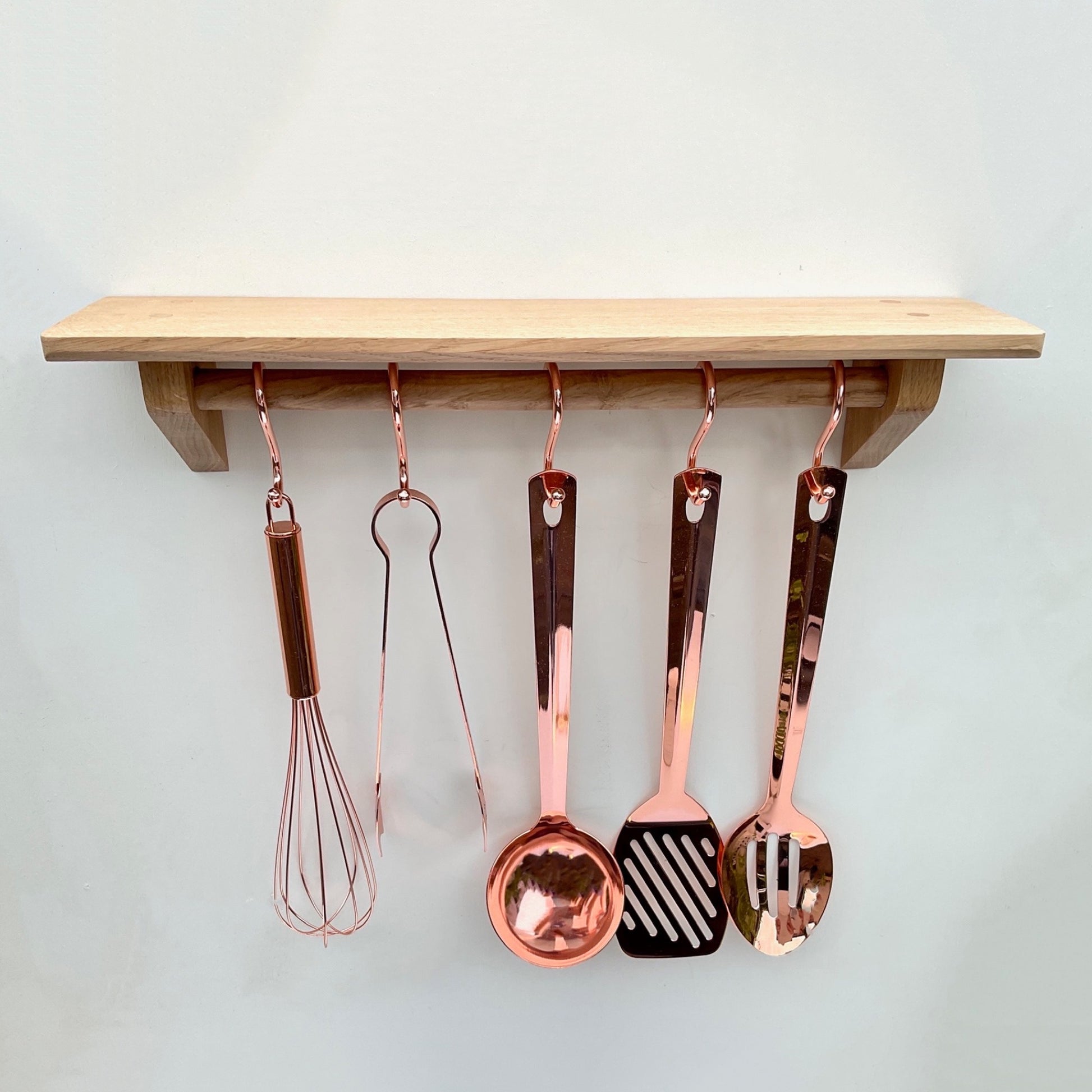 Oak kitchen shelf with utensil rail and copper utensil hooks